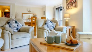 A living room with two sofas, a coffee table, a lamp, and a painting on the wall. - 3 Bed in Ambleside (oc-87524) (Ambleside)