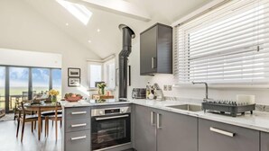 Una cocina moderna con una isla grande, horno empotrado y vistas al exterior.