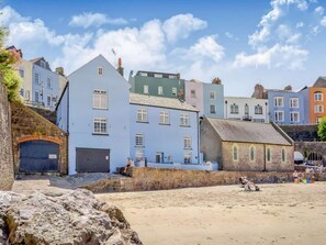 A coastal town with colorful buildings, a sandy beach, and a stone wall. - 2 Bed in Tenby (oc-88608) (Tenby)