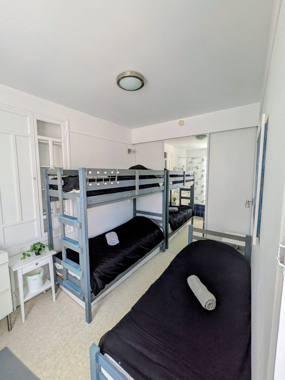 Een slaapkamer met een stapelbed, een bureau en een garderobe.