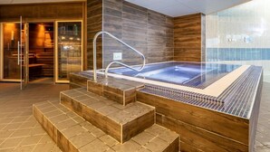A modern indoor pool area with a glass-enclosed hot tub, wooden steps, and a tiled floor. - 2 Bed in Saltash (oc-87715) (Saint Mellion)