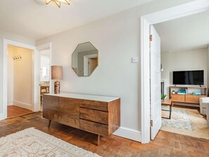 Ein modernes Wohnzimmer mit einem Holzkasten, einem großen Spiegel und einem Fernseher.