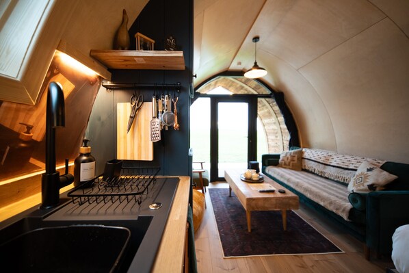 Un espacio de estar acogedor y funcional, con kitchenette, sofá y zona de comedor.
