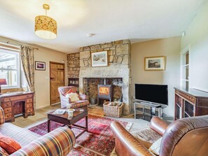 A cozy living room with a stone fireplace, leather sofas, a television, and a wooden desk. - 2 Bed in Alnwick (oc-87559) (Bilton)
