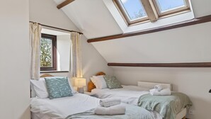 A bedroom with two beds, a skylight, a window, and a radiator. - 4 Bed in Newport (oc-88913) (Porchfield)