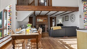 A spacious loft with a dining area, a fireplace, a sofa, and a staircase. - 4 Bed in Newport (oc-88913) (Porchfield)