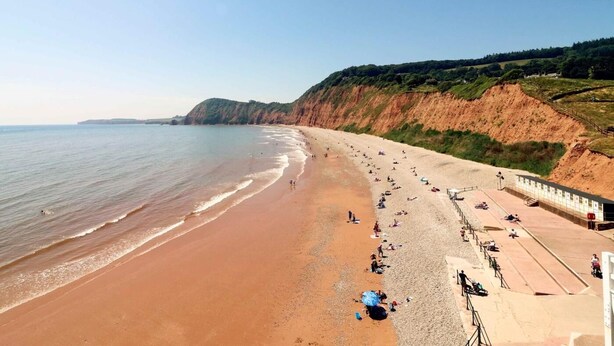 A beach with a long stretch of sand, a cliff on one side, and a clear sky. - 3 Bed in Budleigh Salterton (oc-88004) (Otterton)
