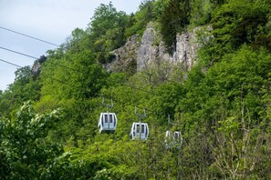 Un sistema de telefèric enmig de vegetació exuberant i penya-segats rocosos.
