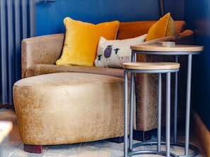 A modern living room with a sectional sofa, a round coffee table, and a small side table.