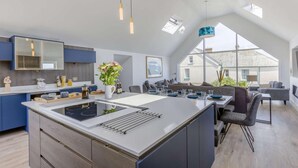 Una cocina moderna con una isla grande, electrodomésticos integrados y un comedor con vistas.