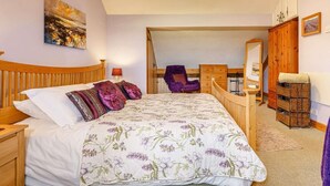 Ein Schlafzimmer mit Bett, Schreibtisch, Stuhl, Kleiderschrank und Spiegel.