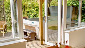 A patio with a table and chairs, a grill, and a view of greenery. - 2 Bed in Saltash (oc-88308) (Notter)