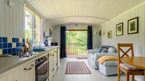 Ett mysigt kök med en matplats, ett stort fönster och utsikt över grönområden.