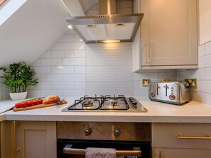 Eine moderne Küche mit einem Gasherd, einem Toaster und einer Pflanze auf der Arbeitsfläche.