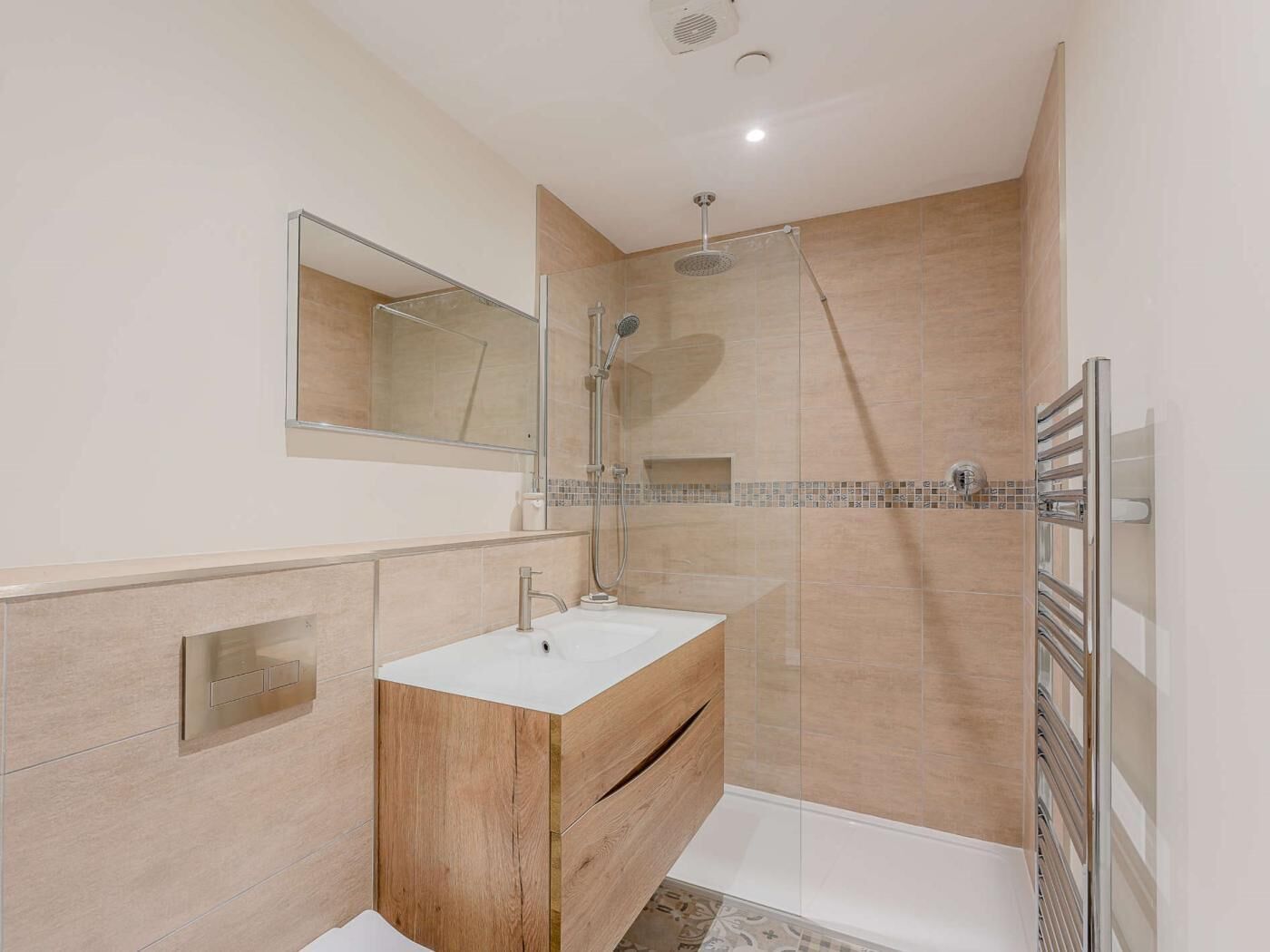 Een moderne badkamer met een douche, een wastafel en een spiegel.