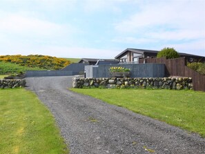 A gravel driveway leading to a house with a stone wall and wooden fence. - 2 Bed in Newton Stewart (oc-88645) (Auchenmalg)