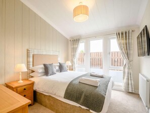 A bedroom with a bed, bedside tables, a lamp, curtains, and a view through the window. - 2 Bed in Newton Stewart (oc-88645) (Auchenmalg)