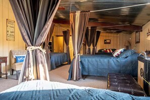 Una habitación con dos camas, techo de madera y un cartel que dice 'Family Rules'.
