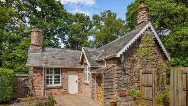 A stone cottage with a chimney, a door, and a small garden area. - 1 Bed in Brecon (oc-88748) (Trallong)