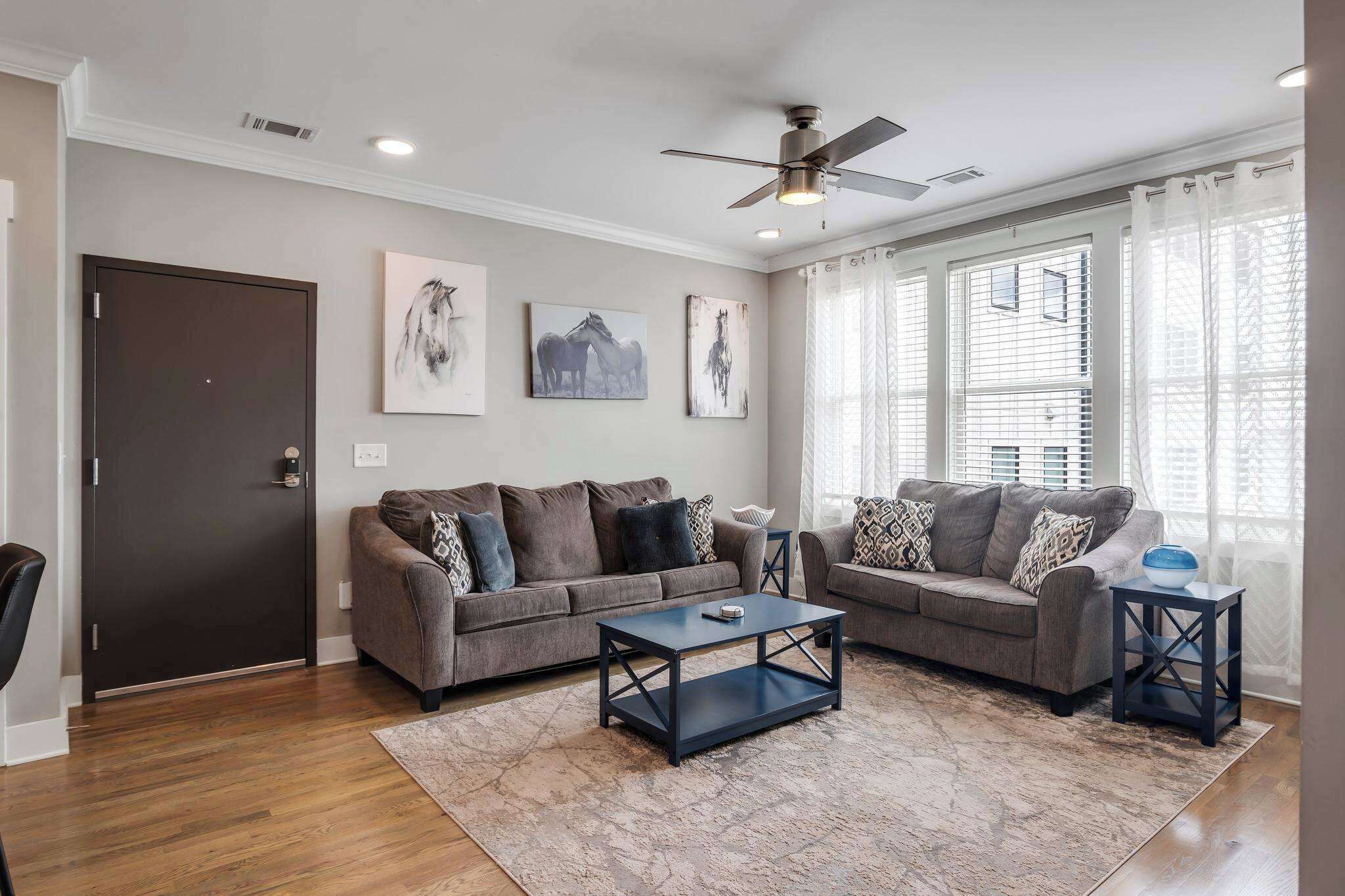 A living room with two sofas, a coffee table, and artwork on the walls.
