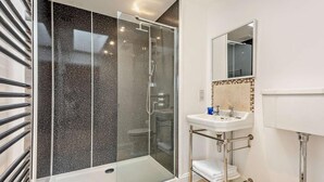 A modern bathroom with a glass-enclosed shower, a white sink with a mirror above it, and a toilet. - 2 Bed in Ventnor (oc-88857) (Niton)