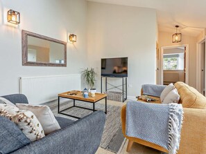 A modern living room with a sofa, armchair, coffee table, and a television. - 2 Bed in Ventnor (oc-88857) (Niton)