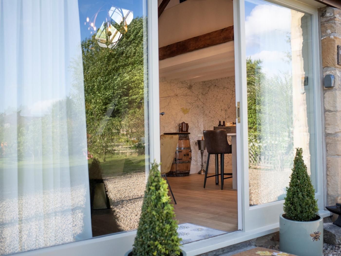 Un interno moderno con zona pranzo, parete in pietra e vista sull'esterno.