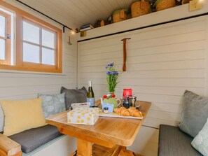 A cozy room with a wooden bench, a table with a bottle of wine, a vase with flowers, and a tray with pastries. - 1 Bed in Canterbury (oc-88795) (Chillenden)