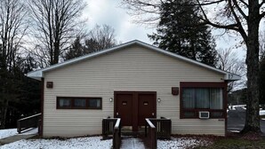 A single-story building with a front entrance, a small porch, and a covered area with a bench. - Cozy 1-bedroom hotel room, Hamilton - #306 Mohawk (Hamilton)