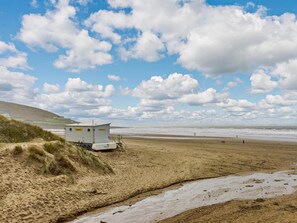 A beach with a small white building, possibly a lifeguard station, near the water's edge. - 2 Bed in Braunton (oc-87750) (Croyde)
