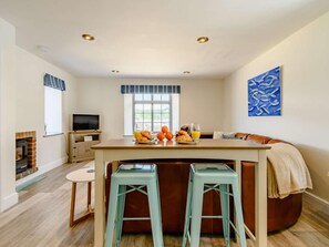 Eine moderne Küche mit Essbereich, Kamin und Fernseher.