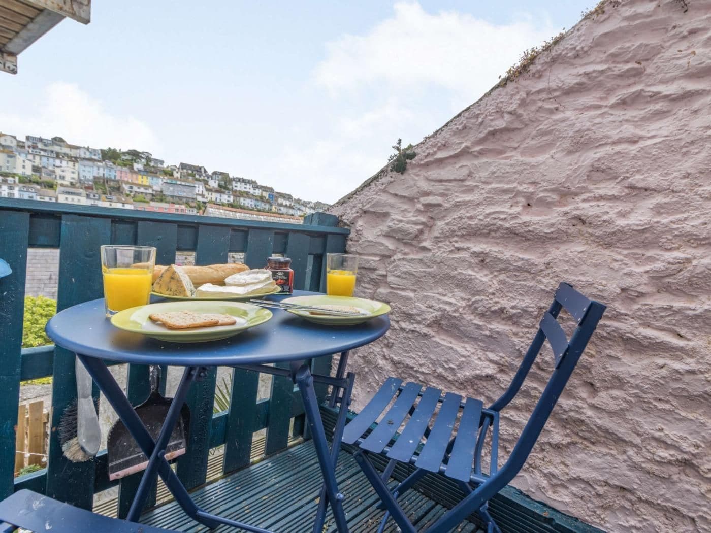 Ein Tisch mit Frühstücksangeboten und ein Stuhl auf einem Balkon mit Blick auf eine Hügellandschaft.
