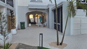 A courtyard with a seating area, a gate, and potted plants.