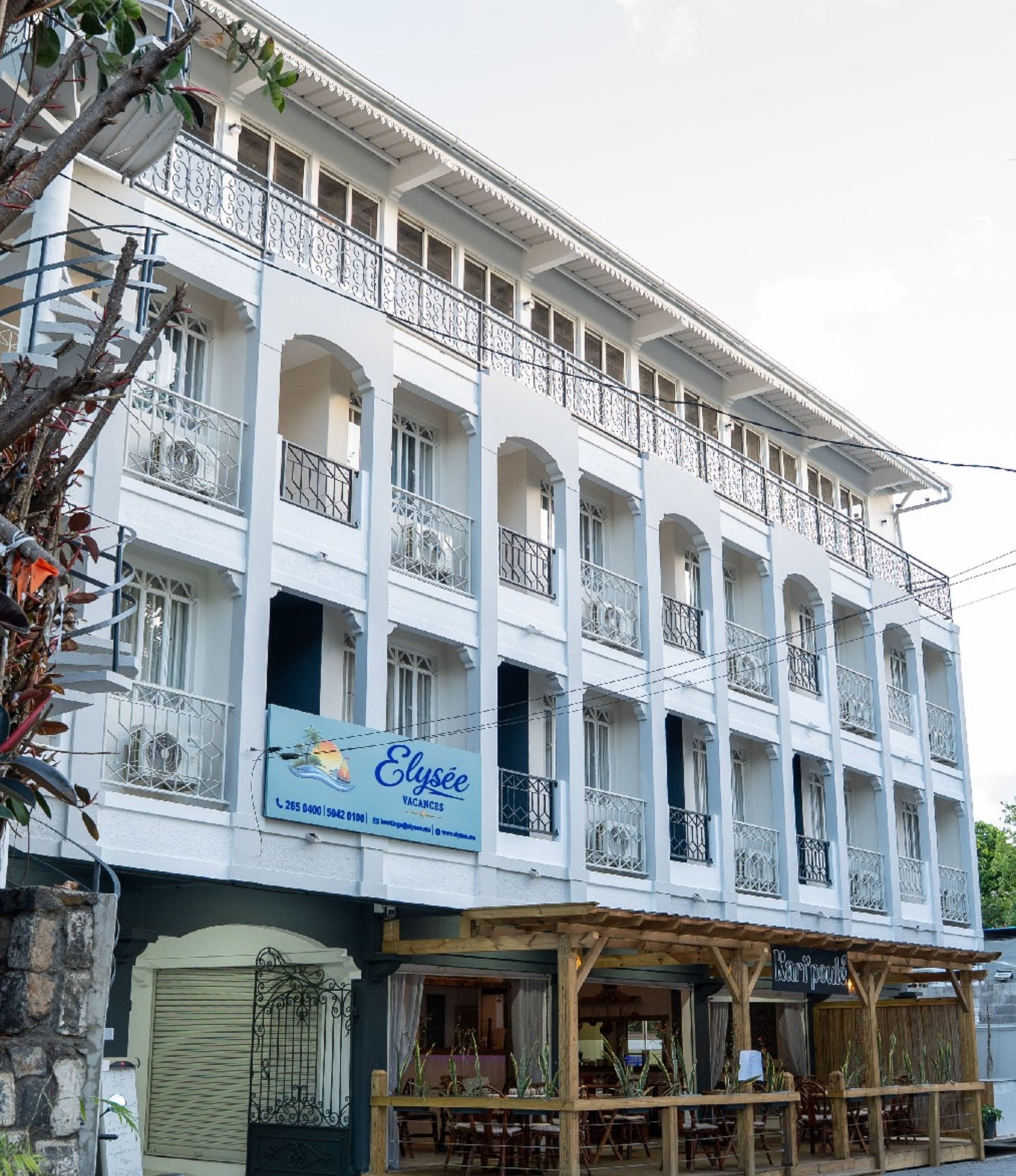 A multi-story building with balconies, a sign advertising 'Clyse Vacances,' and a ground-level restaurant.