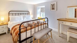 A bedroom with a bed, bedside tables, a bench, a dresser, and a mirror. - 3 Bed in Ulverston (oc-87960) (Penny Bridge)