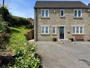 A stone building with a black door, multiple windows, and a bench outside. - 5 Bed in Matlock (oc-88486) (Crich)
