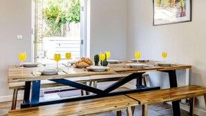 Comedor con mesa de madera, bancos y vistas a zonas verdes.