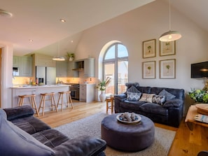 Ein zeitgemäßer Wohnraum mit einer Küche, einem Sofa und einem Couchtisch.