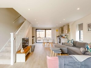 Ein modernes Interieur mit Treppe, Essbereich, Küche und Wohnbereich.