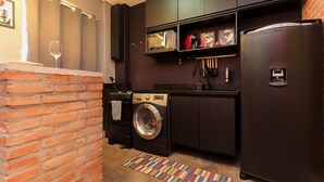 Cocina compacta con lavadora, refrigerador y microondas.