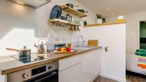 A modern kitchen with built-in appliances, wooden countertops, and a skylight.