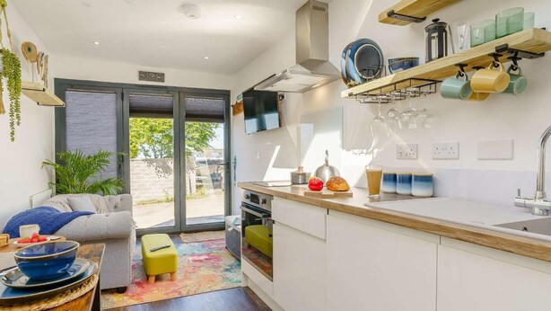 A modern kitchen with a wooden countertop, a built-in oven, and a large window.