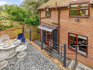 A brick house with a patio area, outdoor seating, and a covered window. - 2 Bed in Ripon (oc-88051) (Ripon)