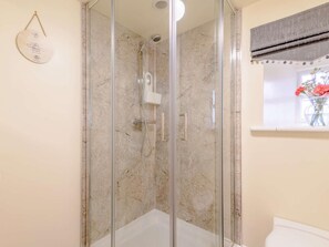 A glass-enclosed shower with a marble wall, a white toilet, and a window with a curtain. - 1 Bed in Harrogate (oc-88520) (Pateley Bridge)