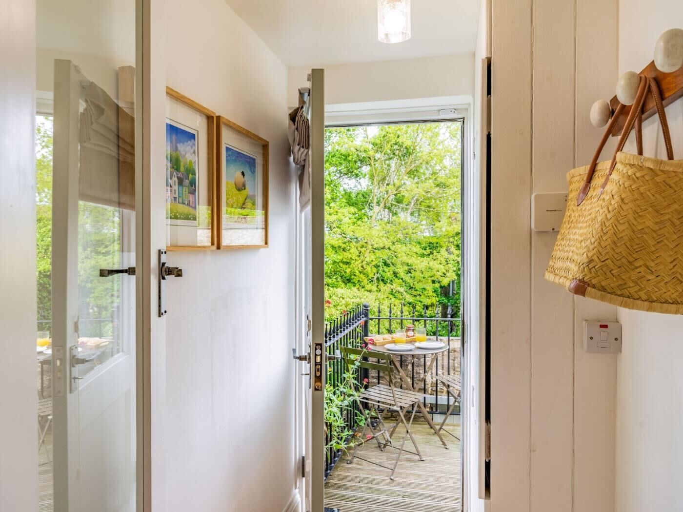 Een kamer met een deur die uitkomt op een balkon, inclusief een tafel, stoelen, een hangmand en wanddecoratie.