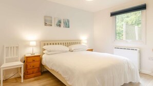A bedroom with a bed, bedside lamps, a chair, a window, and artwork on the wall. - 2 Bed in Saltash (oc-88313) (Notter)
