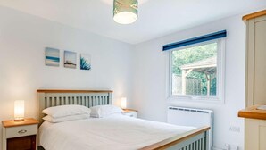 Quarto com cama, mesas de cabeceira, janela com vista e luminária no teto.