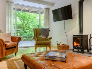 A living room with a sofa, armchair, ottoman, and a fireplace.