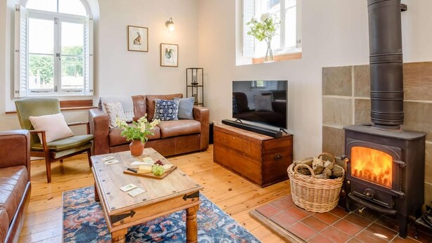 A cozy living room with a fireplace, a sofa, a television, and a coffee table. - 4 Bed in Buxton (oc-88196) (Hartington)
