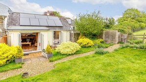 A house with a patio, a garden, and a solar panel on the roof. - 1 Bed in Totnes (oc-88098) (North Huish)